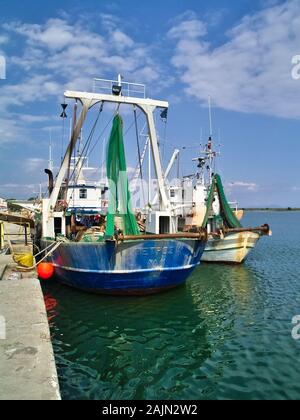 Circuizione le navi da pesca con attrezzature per il porto di Porto Lagos sotto il cielo blu con nuvole. Foto Stock