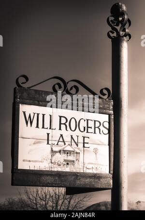 Close up di piastrelle pittorico raffigurante Garrett house incorniciato in un raffinato Cartello in metallo titolare la lettura di Will Rogers Lane, contro un cielo blu in Tubac, AZ Foto Stock