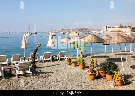 Spiaggia vuota al mattino presto con barche e il castello in background, bodrum, Turchia Foto Stock