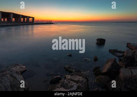 Sunrise drammatica con acqua setosa vista Al uqair rovinato fort lato mare Arabia Saudita. Foto Stock