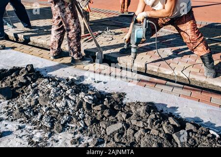 I lavoratori di cui pavimentazione in lastre. Due lavoratori laici di lastre per pavimentazione. Foto Stock