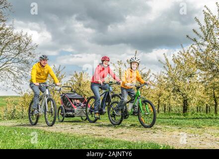 Godendo di primavera la natura durante una gita in bicicletta con la famiglia Foto Stock