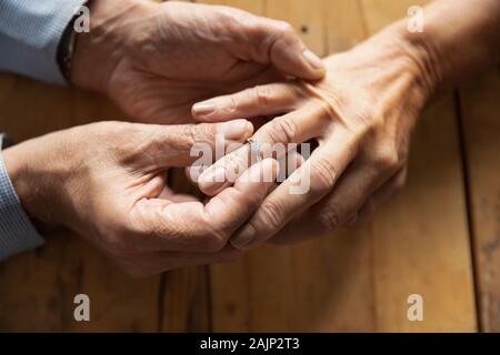 L uomo rende la proposta di matrimonio alla donna di mettere l'anello di matrimonio Foto Stock