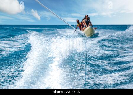 Un gruppo di persone che gustano la banana riding. acqua sport concept. Foto Stock