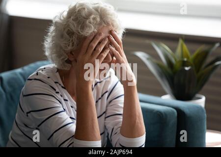 Donna anziana coperto il viso con le mani il pianto si sente disperati Foto Stock