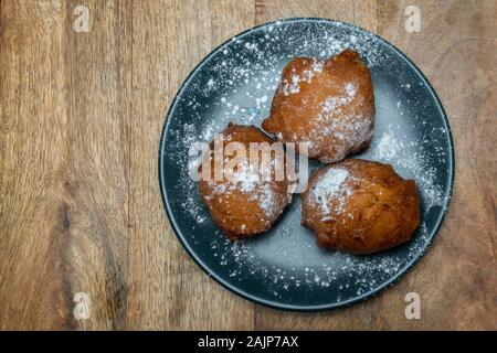 Tradizionale ciambella olandese su una piastra con lo zucchero in polvere su di esso. Chiamato oliebollen nei Paesi Bassi. Per la maggior parte consumati per la Vigilia di Capodanno. Foto Stock