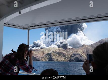 (200105) -- PECHINO, 5 gennaio 2020 (Xinhua) -- Una persona prende le foto di una eruzione vulcanica in Nuova Zelanda White Island, Dicembre 9, 2019. Un totale di 19 persone è stato confermato morto in una eruzione vulcanica in Nuova Zelanda isola bianca nella parte orientale della Baia di Planty dell'Isola del nord. Il vulcano ha eruttato il 9 dicembre 2019, quando 47 persone erano sull'isola. (Foto fornite da Michael Schade/Handout via Xinhua) Foto Stock