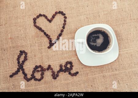 Un vintage immagine per mostrare l'amore con i chicchi di caffè e una tazza di caffè Foto Stock