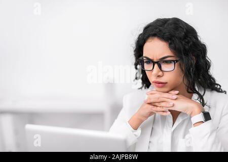 Analizzando il lavoro. Focalizzato donna messicana utilizzando laptop, facendo qualche ricerca. Spazio di copia Foto Stock