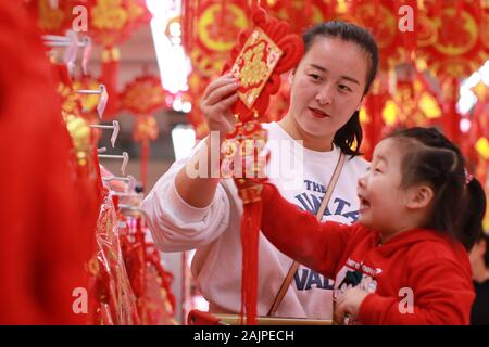 I clienti cinesi shop per i tradizionali decorazioni rosso in preparazione per il prossimo Anno Nuovo Cinese o Festival di Primavera in un supermercato di Xiamen Foto Stock