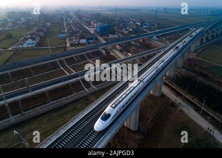 Un CRH (Cina ferrovia ad alta velocità) bullet train viaggia su di una linea ferroviaria ad alta velocità in Huai'an City, est della Cina di Jiangsu Province su Gennaio 4th, 2020. Foto Stock