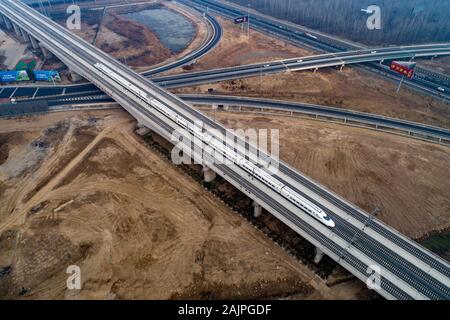 Un CRH (Cina ferrovia ad alta velocità) bullet train viaggia su di una linea ferroviaria ad alta velocità in Huai'an City, est della Cina di Jiangsu Province su Gennaio 4th, 2020. Foto Stock