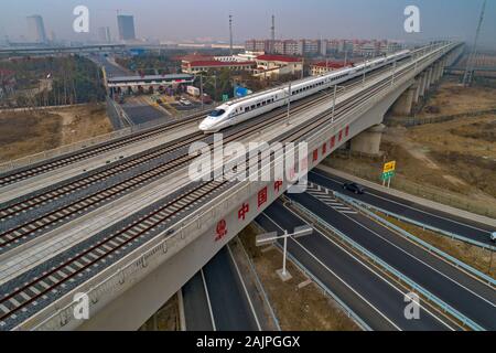 Un CRH (Cina ferrovia ad alta velocità) bullet train viaggia su di una linea ferroviaria ad alta velocità in Huai'an City, est della Cina di Jiangsu Province su Gennaio 4th, 2020. Foto Stock