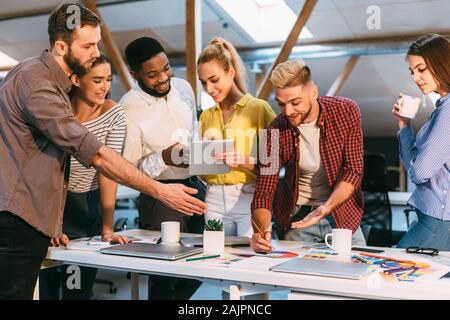 I giovani designer di discutere il nuovo schema di colori per progetto, team il brainstorming in office Foto Stock