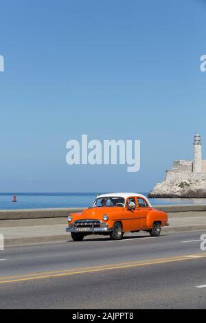 Vecchia auto classica, il Malecon, Castillo del Morro (fondo), Havana, Cuba Foto Stock