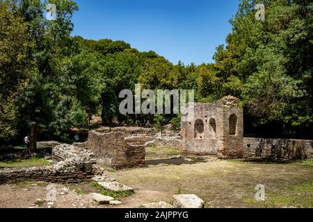 Butrinto, ALBANIA - Giugno 7, 2019: lavori di scavo in corso. Bella calda giornata di primavera e rovine archeologiche a albanese patrimonio UNESCO. Fotografia di viaggio con fresco verde della flora Foto Stock