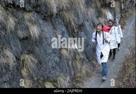 (200105) -- PECHINO, 5 gennaio 2020 (Xinhua) -- Guan Yanping (anteriore) e i suoi colleghi a piedi su un sentiero di montagna in Bingzhongluo township di Lisu prefettura autonoma di Nujiang, a sud-ovest della Cina di Provincia di Yunnan, Gennaio 13, 2019. Guan, 51, un esperto ostetrica, ha volontariamente di fornire servizio medico in Bingzhongluo Township fin dal marzo 2017. Per raggiungere i villaggi che sono collegati senza autostrade, Guan e i suoi colleghi hanno dovuto camminare per questi villaggi durante l'imbracciatura apparecchiature mediche con ceste. Ella ha marciato oltre 300 volte sui ripidi e stretti sentieri di montagna a trattare le persone in 46 Foto Stock