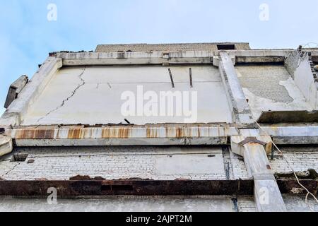 Una parte della parete di calcestruzzo del distrutto edificio. Vista dal basso. Foto Stock
