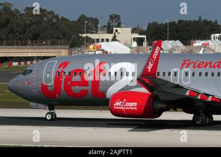 Boeing 737 ng jet del passeggero aereo appartenente alla British compagnia aerea a basso costo Jet2 uscire da Malta. Vista dettagliata del logo sulla fusoliera anteriore con aletta. Foto Stock