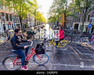 Ciclisti sono il passaggio di un ponte sul canale di Amsterdam del vecchio quartiere Jordaan (Egelantiersgracht) Foto Stock