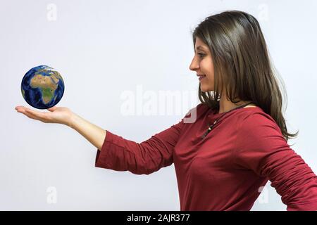 Il mondo a portata di mano. Inquadratura concettuale per il successo aziendale. Donna isolato su sfondo bianco Foto Stock