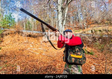 Cacciatore con arma a caccia nella foresta Foto Stock