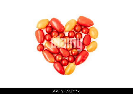 Cuore di pomodoro su sfondo bianco. Diversi di rosso e di giallo fresco, pomodoro organici in forma di cuore. Dieta e nutrizione concetto. Foto Stock