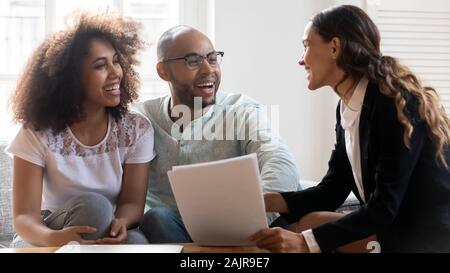 Felice coppia internazionale consulenza con agente immobiliare femmina Foto Stock