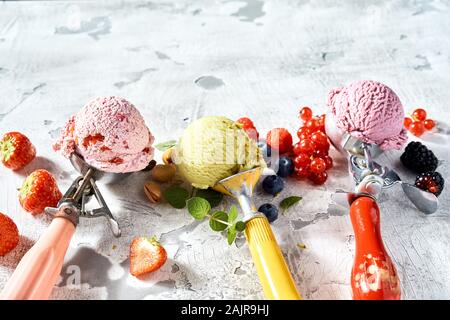 Graffette metalliche con assortimento di Berry e pistacchio ice-cream circondato da ingredienti freschi con copia spazio sopra Foto Stock