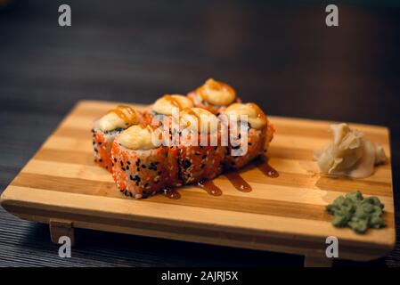 Set di hot sfornati su un vassoio di legno con zenzero e wasabi. Gustosi piatti sushi in un ristorante cinese. Foto Stock
