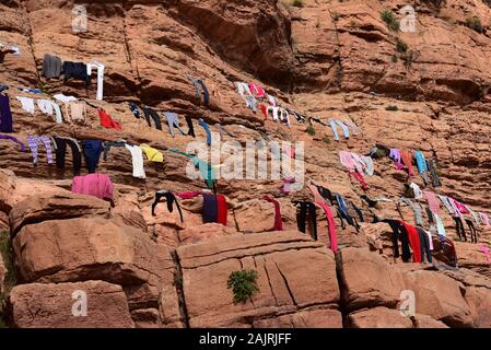 Vita del villaggio - la gente del posto dal villaggio marocchino di Tighza disporre la loro lavanderia per asciugare sulle rocce sotto il sole di mezzogiorno, Nord Africa. Foto Stock