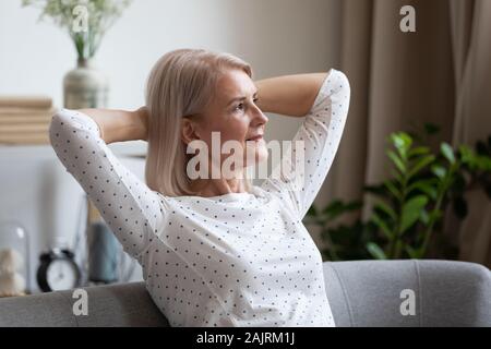 Premurosa donna matura guarda nella distanza dreaming Foto Stock