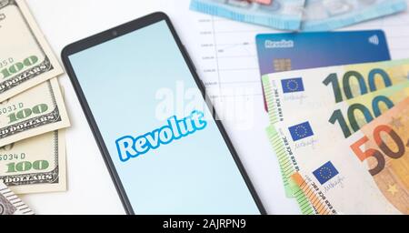 Wroclaw, Polonia - Nov 06, 2019: Revolut logo della banca sullo schermo dello smartphone accanto alle banconote. Revolut Ltd è un regno unito financial technology company che di Foto Stock