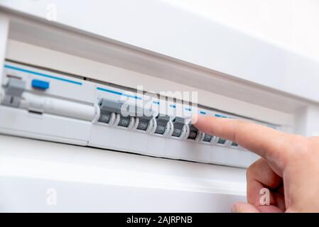 L'uomo disabilita i fusibili corrente. I dispositivi elettrici di protezione Foto Stock