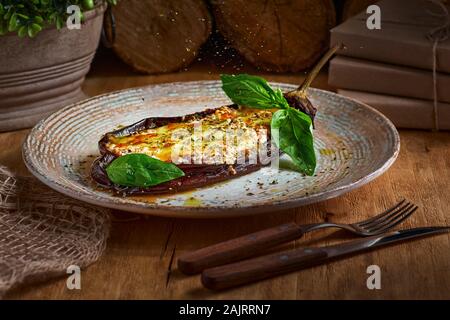 Melanzana, stufati di carne, pomodori, formaggi, delizioso piatto italiano. Sul tavolo di legno vicino fino Foto Stock