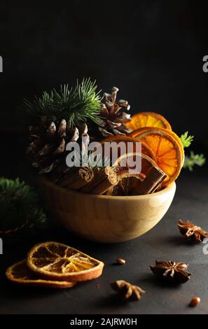 Concetto di Natale. Closeup di composizioni natalizie con fette di arancia essiccate, cannella e anice su sfondo bianco. Foto Stock