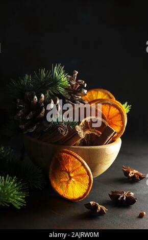 Concetto di Natale. Closeup di composizioni natalizie con fette di arancia essiccate, cannella e anice su sfondo bianco. Foto Stock