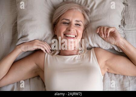 Vista superiore della sorridente donna senior wake up feeling positivo Foto Stock