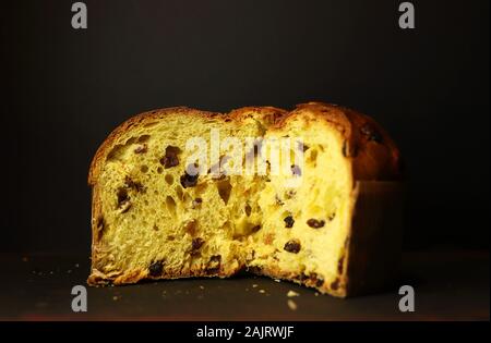 Concetto di cibo italiano. Tradizionale italiano Natale panettone torta con frutta secca su sfondo scuro. Foto Stock