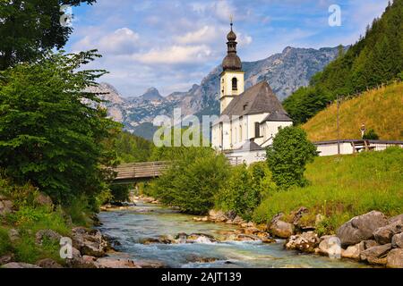 Chiesa di San Sebastiano in un paesaggio con un ruscello di montagna ed Alpi a Ramsau bei Berchtesgaden nel Berchtesgadener Land di Baviera, Germania. Foto Stock