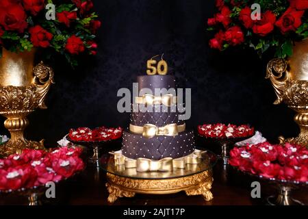 Nero torta di compleanno con i dettagli dorati - Cinquanta anni di anniversario - 50 anni candela Foto Stock