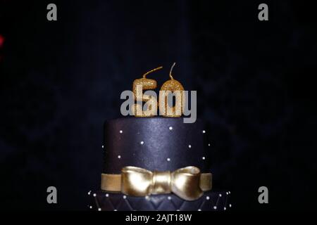 Nero torta di compleanno candela dettaglio con i dettagli dorati - cinquantesimo compleanno - cinquantesimo candela. Foto Stock