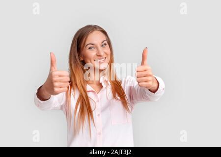Freestyle. Giovane donna in piedi isolato su bianco Thumbs up sorridendo felice Foto Stock