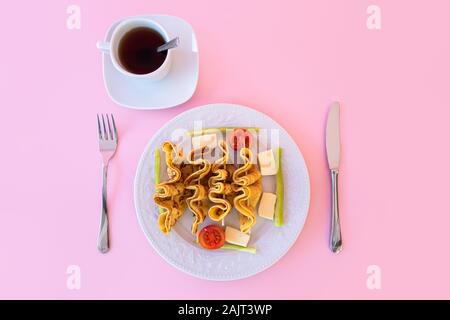 Tea time, coppa del preparato di fresco tè caldo e morbido e leggero come aperitivo di piastra crêpe con sfondo rosa. Foto Stock