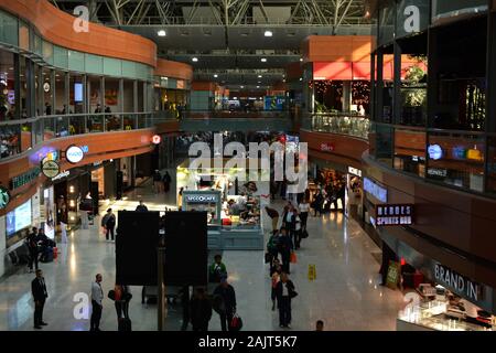 Aeroporto di Istanbul / Turchia - 19 novembre 2019 i negozi di design e fast food utilizzano insegne al neon luminose e display a LED per tentare i viaggiatori Foto Stock