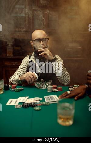 Barbuto giocatore di poker con sigaro, casinò Foto Stock