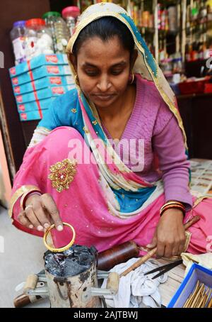 Una craftswoman dei bangles nel mercato rasta di Maniharon a Jaipur, India. Foto Stock