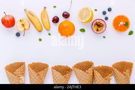 Lay piatto vari tipi di frutta fresca mirtillo ,fragola ,orange ,banana ,il frutto della passione ,apple e ciliegia setup su sfondo bianco . Estate e menu dolce Foto Stock
