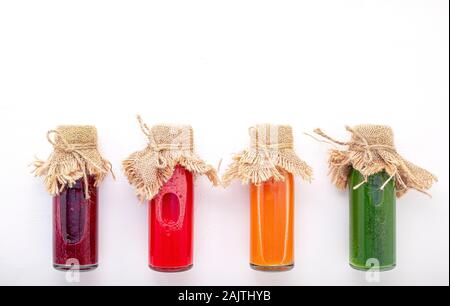Colorati Frullati salutari e di succhi di frutta in bottiglie su sfondo bianco con copia spazio. Foto Stock
