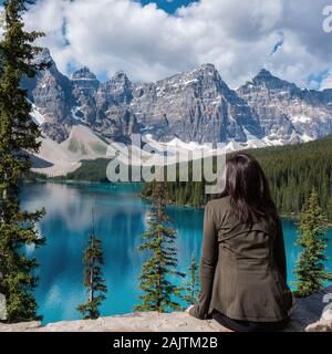 Turista femminile guardando la vista al Lago Moraine nel Parco Nazionale di Banff, Canadian Rockies, Alberta, Canada. Foto Stock